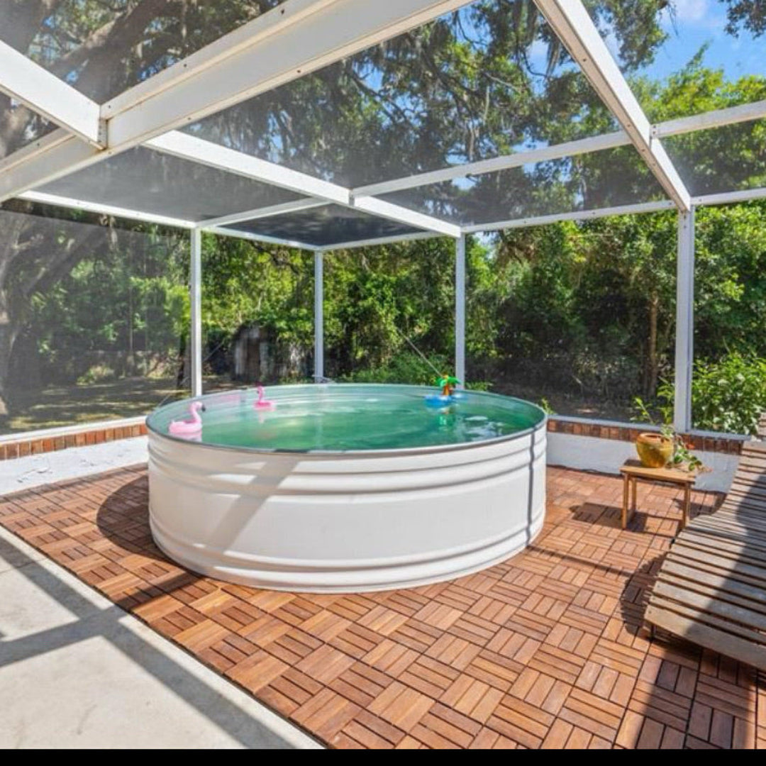Small above-ground pool in a screened-in backyard with wooden deck and trees in the background.