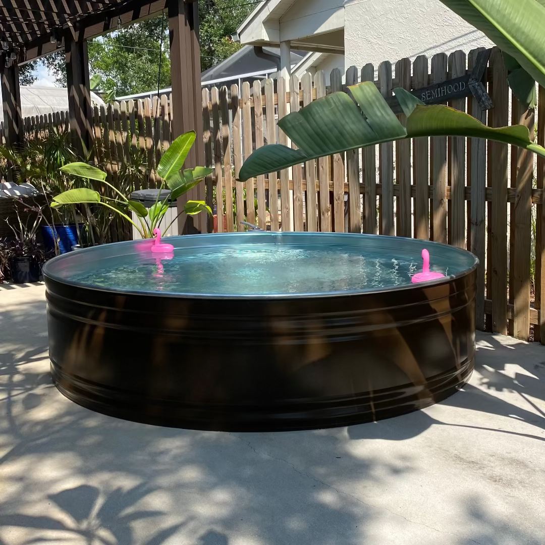 Round above-ground pool with pink floaties in a backyard setting