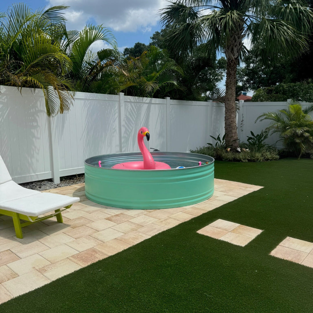 Small green above-ground pool with a pink flamingo float in a backyard setting.