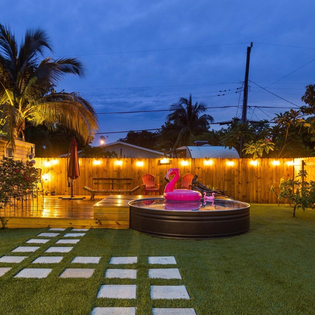 Backyard with inflatable flamingo pool toy, checkered pool area, and string lights.
