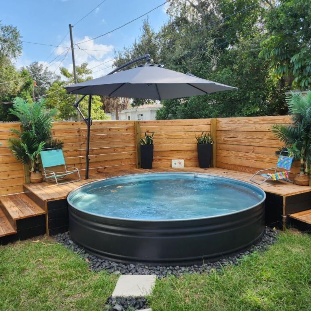 Small round pool in a backyard with wooden deck, chairs, and plants.