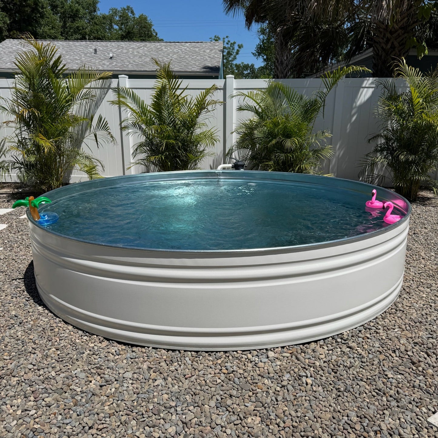 Round above-ground pool with inflatable toys in a backyard setting