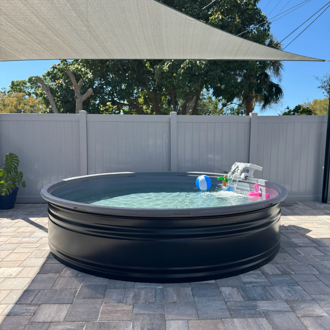 Portable inflatable pool on a patio with a shade sail and trees in the background