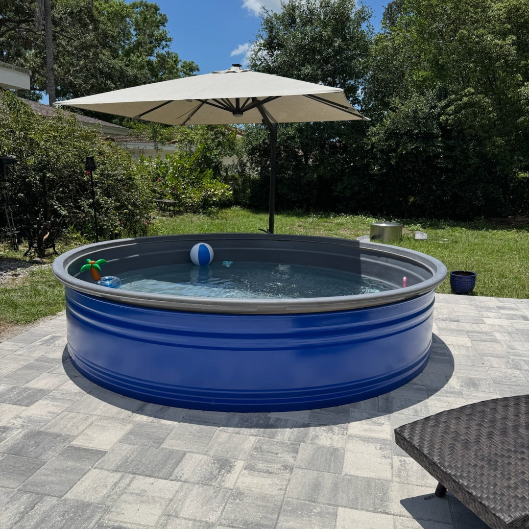 Blue above-ground pool with a white umbrella and lounge chair on a patio
