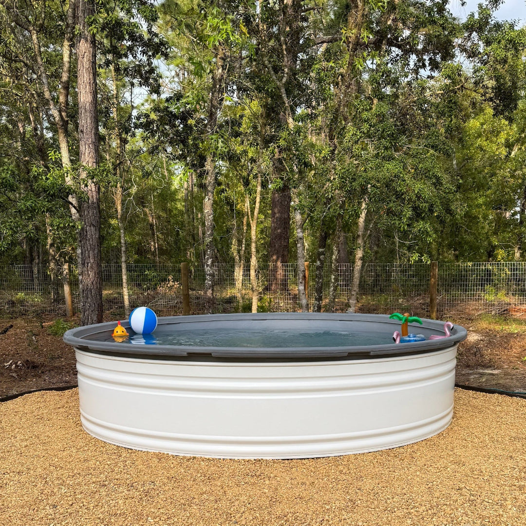 White above-ground pool with toys in a wooded area
