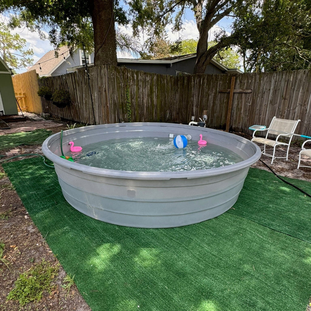 Portable pool with inflatable toys on a grassy backyard