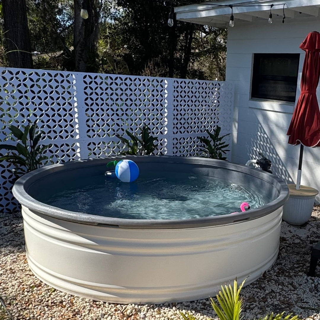 In-ground pool with toys in a backyard setting