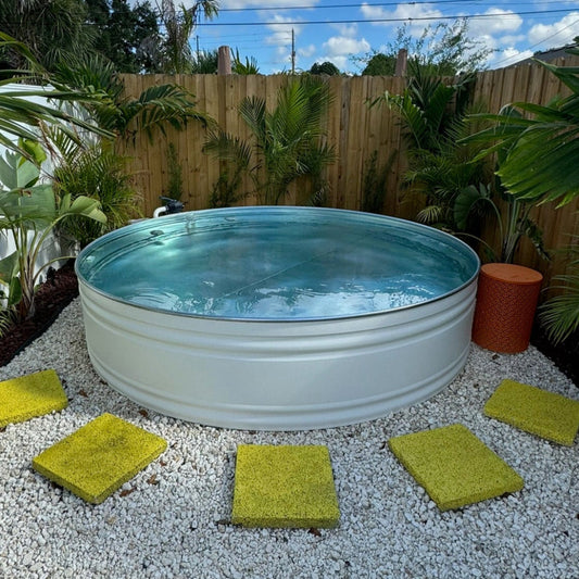 Circular above-ground pool in a backyard with plants and gravel