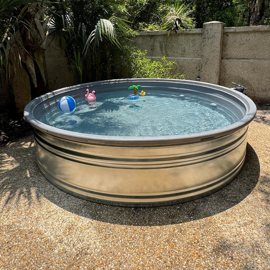 Metallic above-ground pool with toys in a garden setting