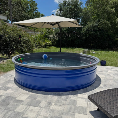 Blue above-ground pool with a white umbrella and lounge chair on a patio