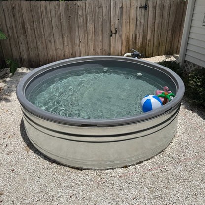 Small above-ground pool with water and toys in a backyard setting.