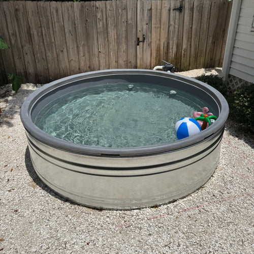 Small above-ground pool with water and toys in a backyard setting.